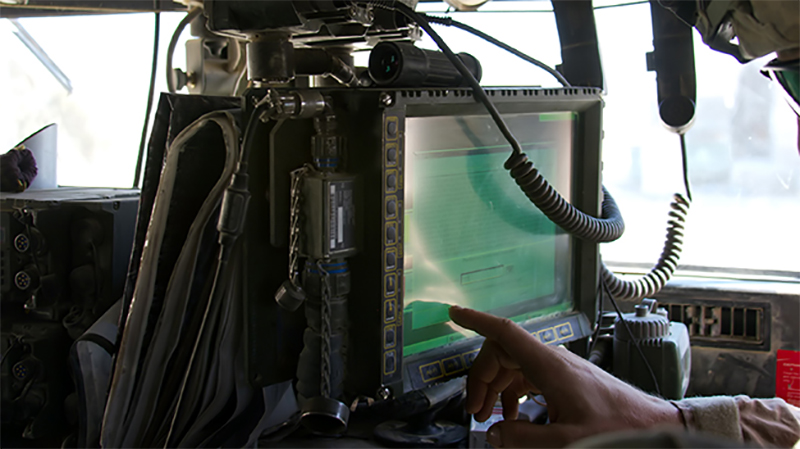 Soldier uses a touchscreen monitor aboard a helicopter