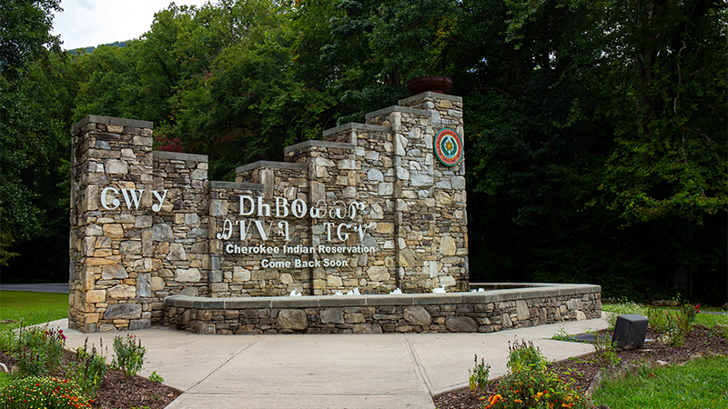 A stonework welcome sign for the Eastern Band of Cherokee Indians’ reservation in Cherokee, North Carolina. The sign is written using both the Cherokee syllabary as well as the English translation which reads ‘Cherokee Indian Reservation / Come Back Soon.’