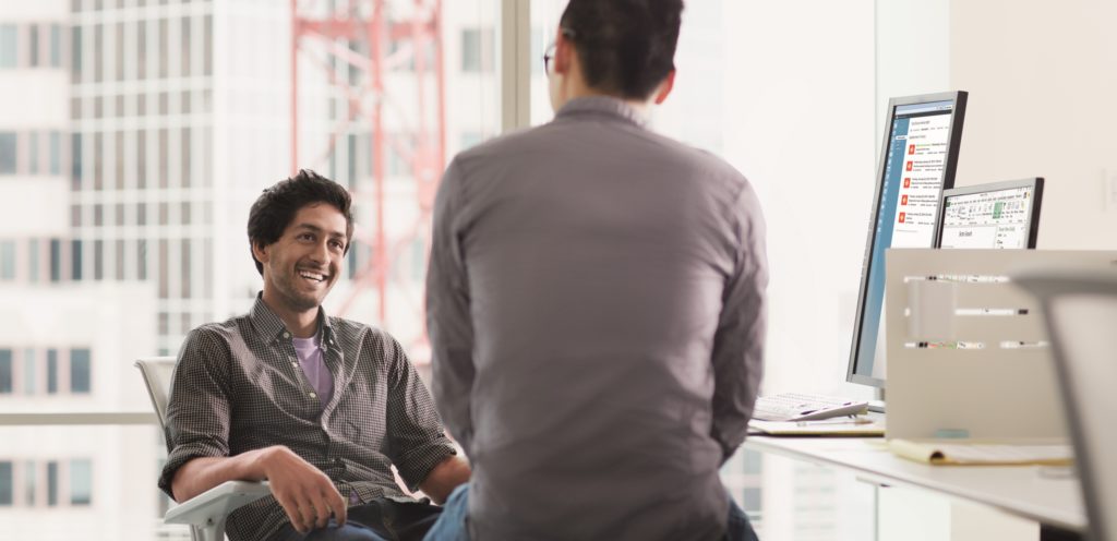 Two men sitting in an office working.