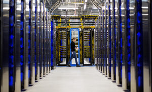 Image of a man walking through a datacenter.