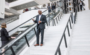 Image of a financial services worker walking down a flight of stairs while checking his phone.