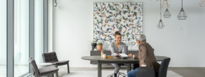 Two Firstline Workers interact with one another over a table.