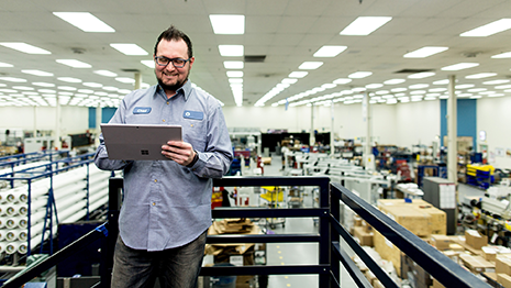 Image of a worker in a warehouse working on a tablet.