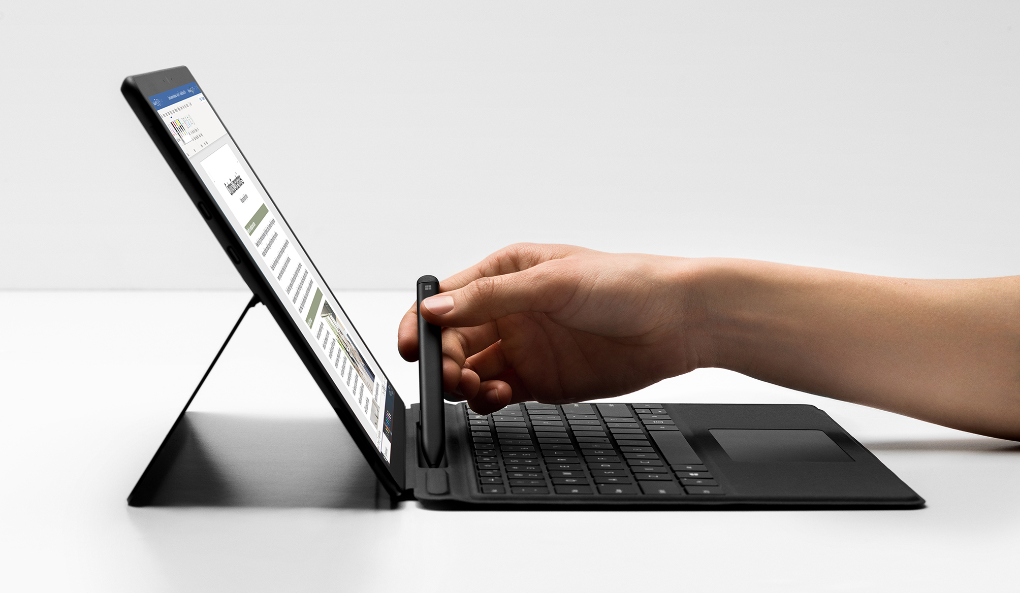 Billede af en hånd, der fjerner en pen fra den nye Surface Pro X.