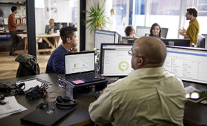 Image of tech workers working at a desk.