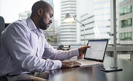 Image of an office worker examining an email on his laptop.