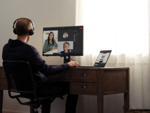 Teams call with headphones at a home desk on a Lenovo ThinkPad X1 Carbon.