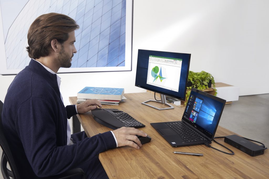 Business manager working on a graph in Excel with his mouse in his hand.