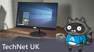 Bit the Raccoon standing next to a Windows 10 desktop computer.