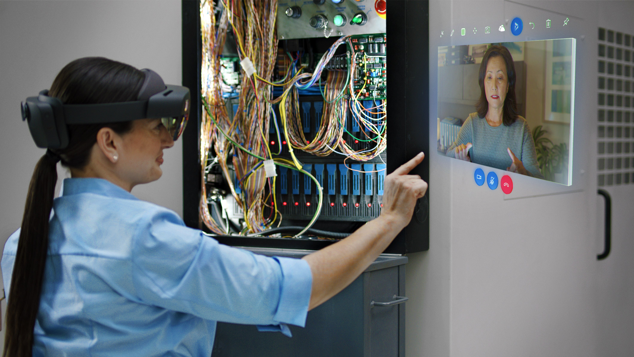Woman interacing with Remote Assist hologram in a wiring project.