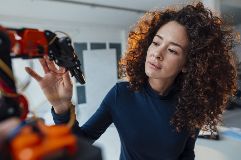 Engineer examining robotic arm in office