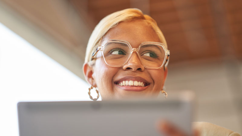 Smiling woman uses a computer tablet