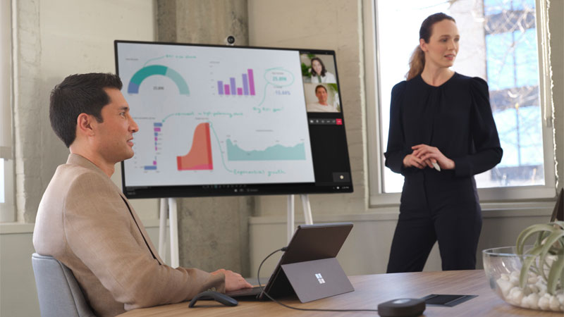 Woman presents data on a Microsoft Surface Hub 2S during a Teams meeting