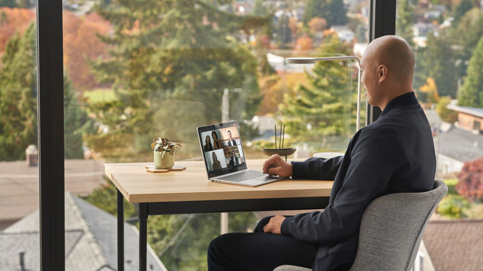 A man attends a virtual meeting on his laptop