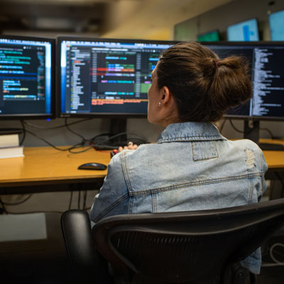 A young woman working on a computer as a green software engineer