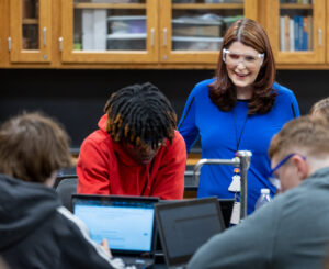 Picture of chemistry teacher, Melissa Higgason working with a group of students in a classroom setting.