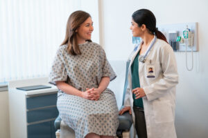 A medical clinician talking with a patient in an exam room. patient