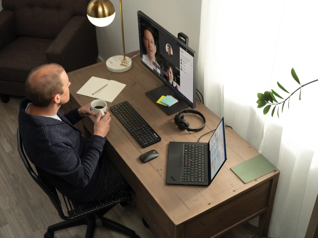 High angle view of a man having a Microsoft Teams meeting on a Lenovo ThinkPad Carbon X1. Remote Working collection. Keywords: remote work, remote working, work from home, working at home, home office, telecommuting, video conference, video call, Microsoft Teams