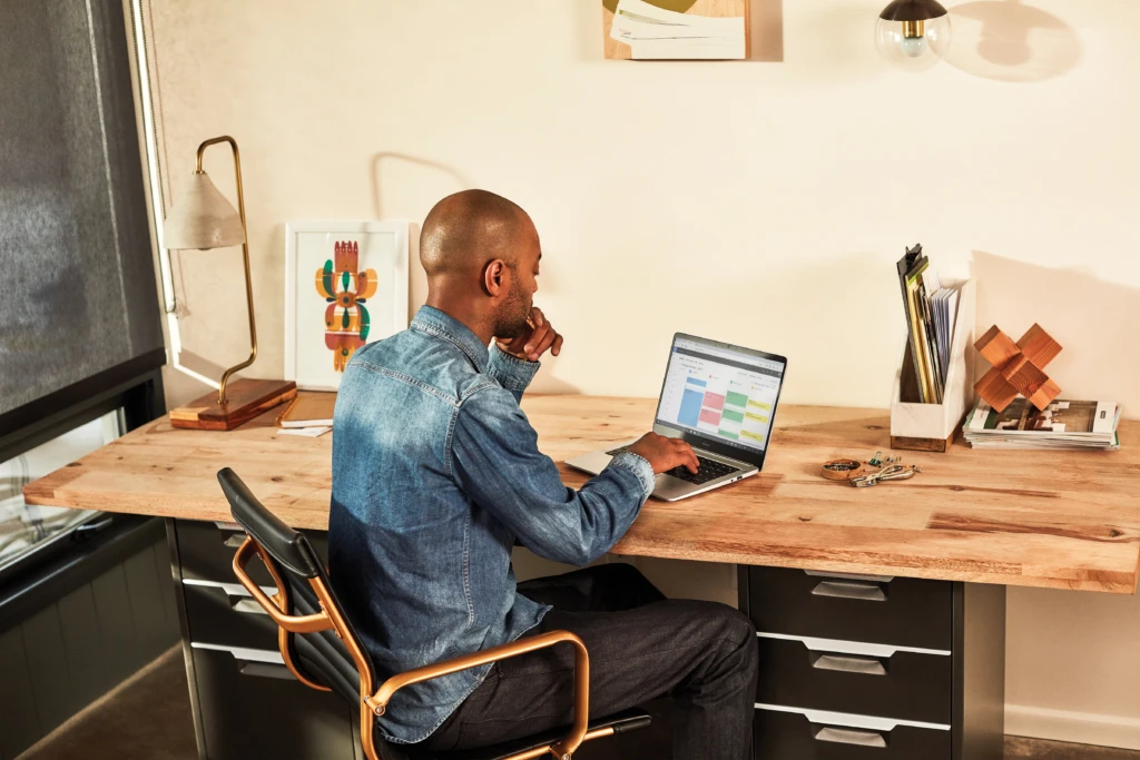 A mand working on his laptop at home, opportunity scoring predictions is accessed from any workplace