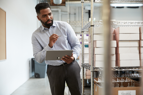 Man standing in a room holding Windows device