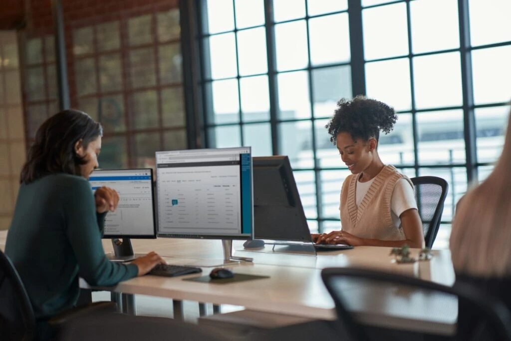 Enterprise office colleagues collaborating in open work space. Keywords: Dynamics 365; operations; man; woman; workers; training