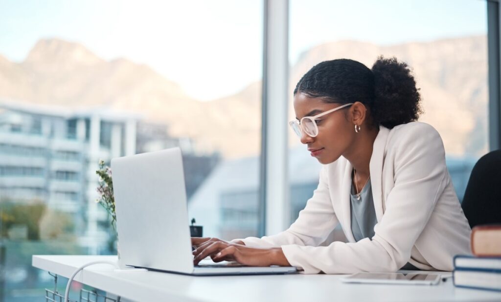 Young businesswoman using a laptop at her desk in a modern office.