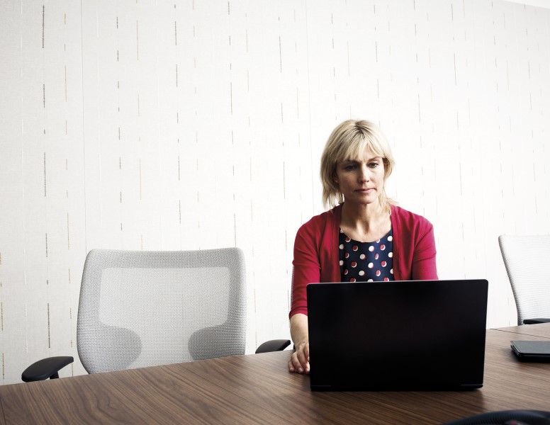 a person sitting at a table using a laptop