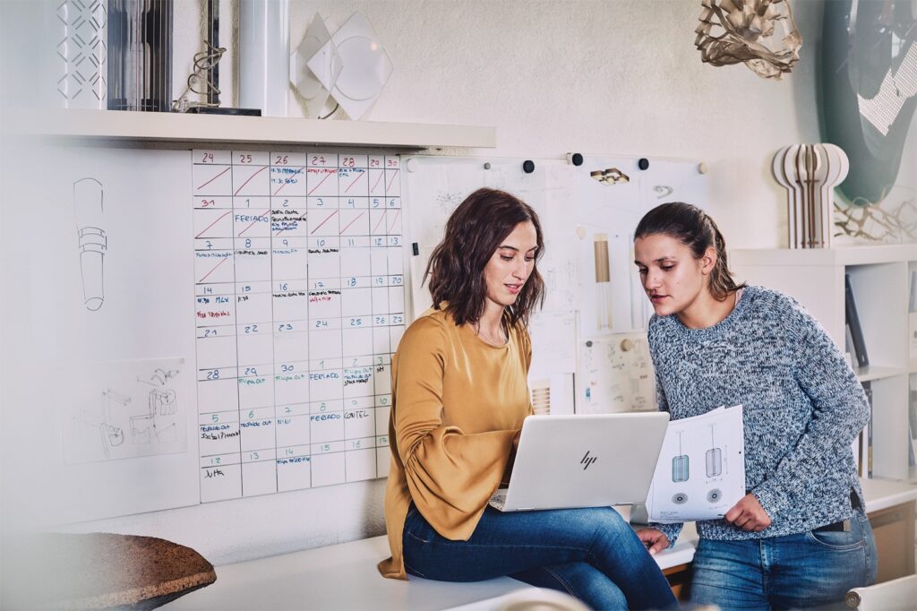 Design project manager analyzing customer experience data with a marketing team member.