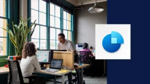 Two coworkers collaborating at a desk next. The image incorporates the Dynamics 365 Sales icon.