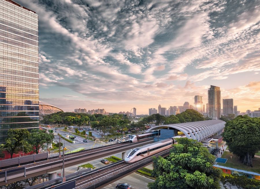 a view of a city on a train track with trees in the background