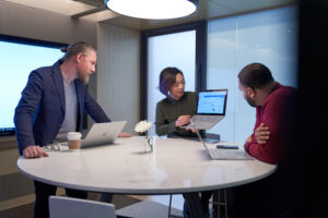 Photo of three colleagues discussing a data maintenance strategy for their organization.
