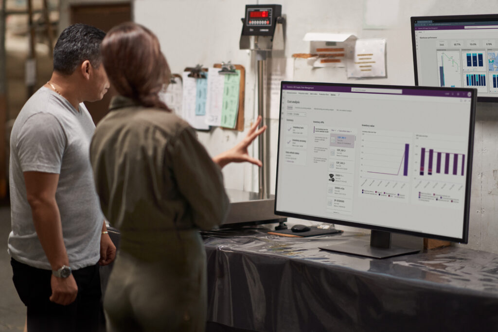 CFO and COO look at graphs on a screen in a textile factory