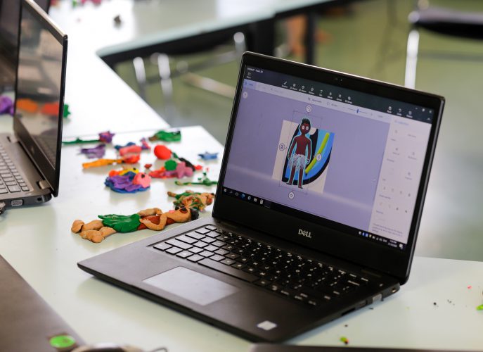 A student generates a 3D model of a character in Paint 3D on a laptop.