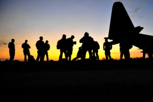 a group of people standing in front of a sunset