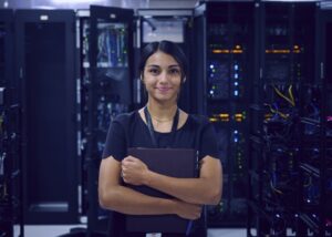 Woman in a server room holding a notebook