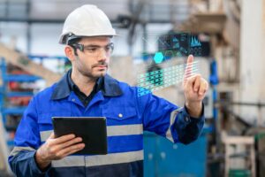 A portrait of a confident engineer touch the button at the screen and use digital tablet in a heavy industrial factory, concepts engineer working in the factory.