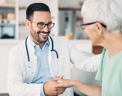 Doctor shaking hands with a patient in an office setting.