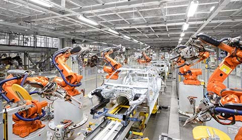 Robots in a factory which are building a car