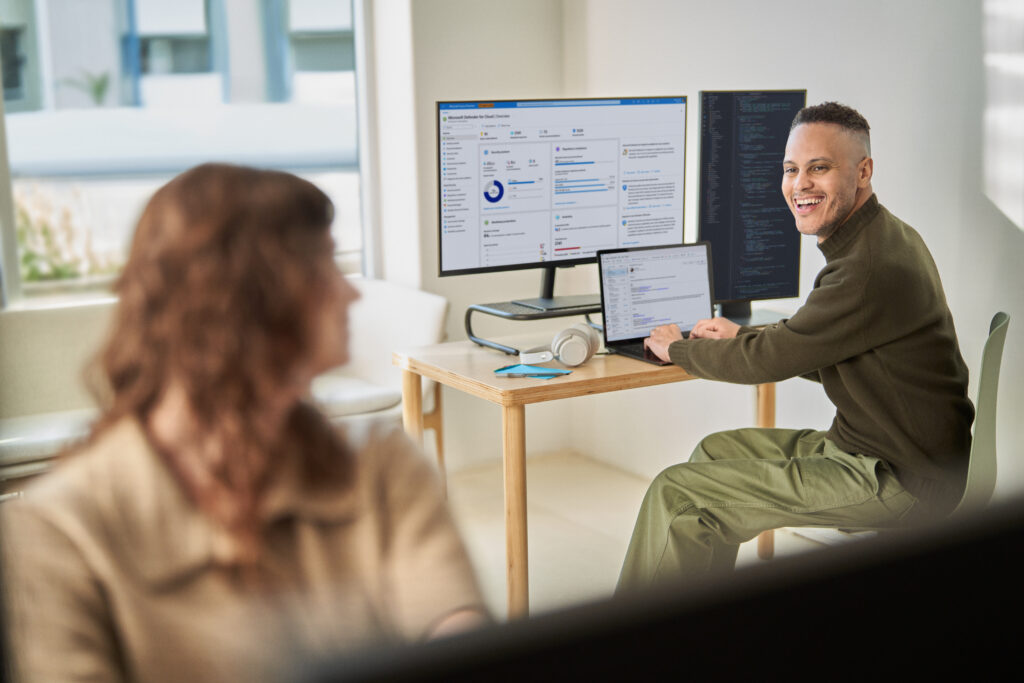 Man collaborating in front of computer screens