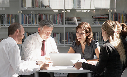 Image of five Korn Ferry employees meeting around a desk.