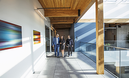 Image of three coworkers walking along a hallway.