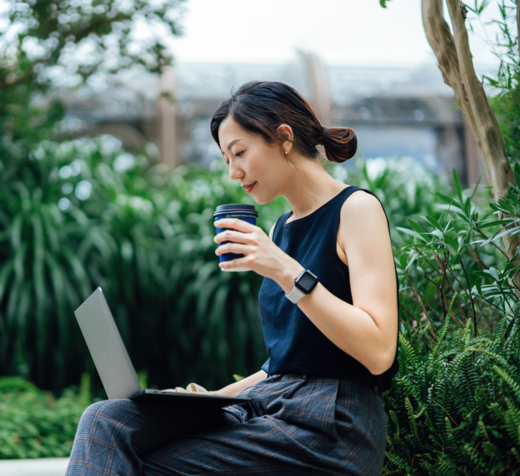 An employee working outside on a laptop