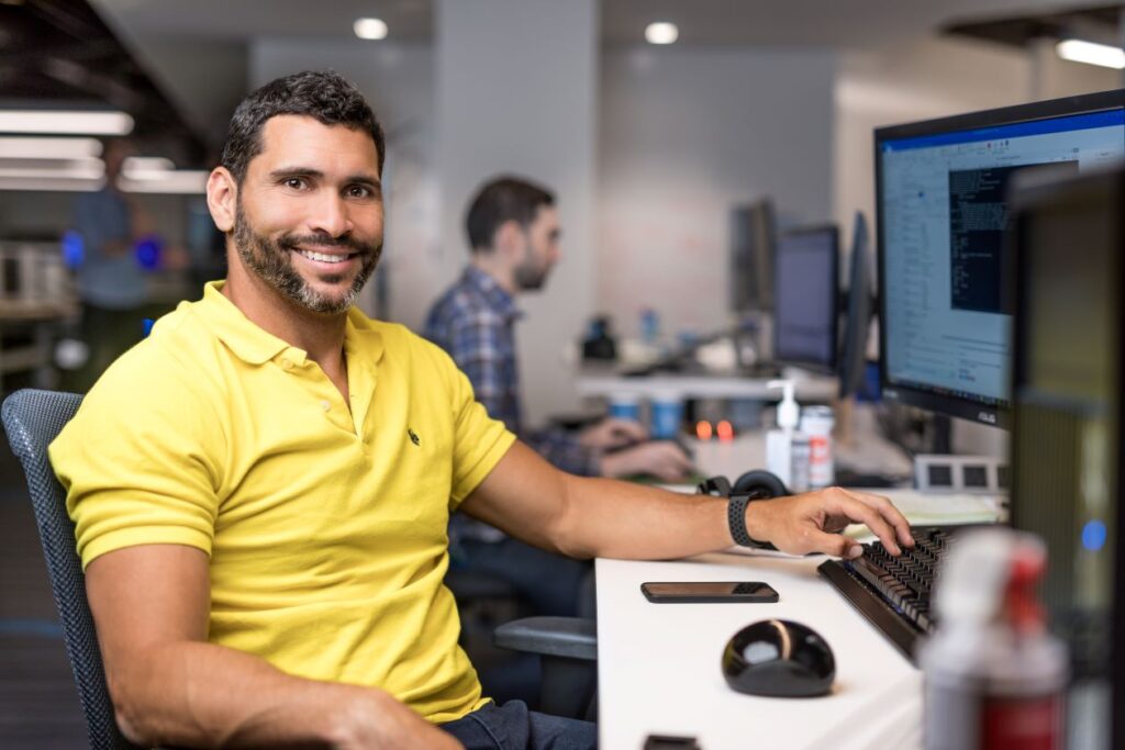 man in yellow shirt at computer