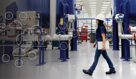 woman wearing a hardhat walking across a factory floor with an overlay of cloud, server and edge-computing icons