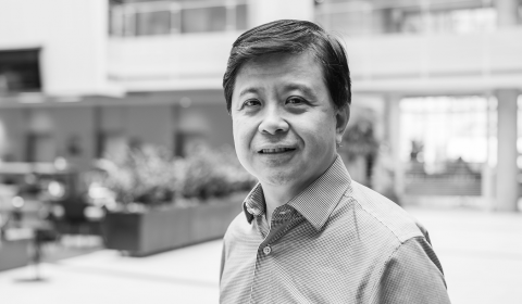 Hsiao-Wuen Hon wearing a suit and tie smiling at the camera