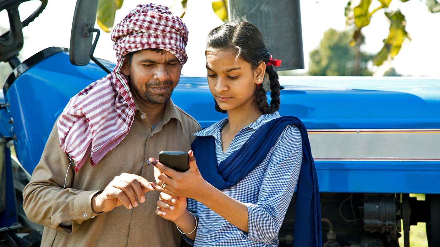 Learn2Earn: photo of a farmer with daughter using mobile phone