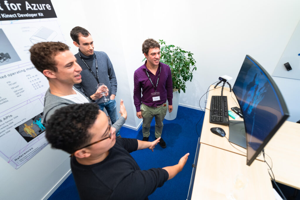 a group of people standing in front of a computer