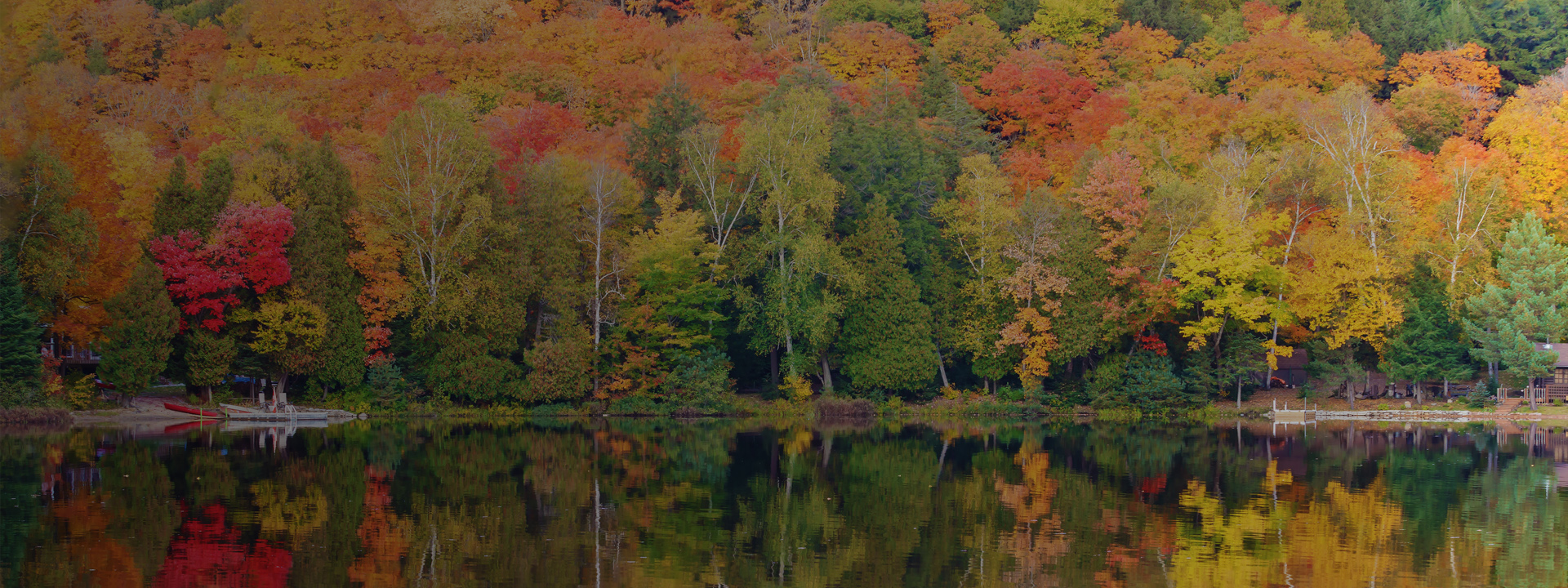 Reflection of fall foliage on a calm lake in Muskoka region, Ontario, Canada where SOSP 2019 is being held.