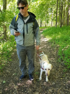 Amos Miller and his dog Saigon use Soundscape on a walk through the forest