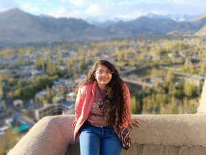 a woman sitting on top of a mountain